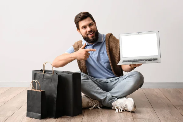 Handsome Man Black Friday Shopping Bags Pointing Laptop Light Wall — Stock Photo, Image