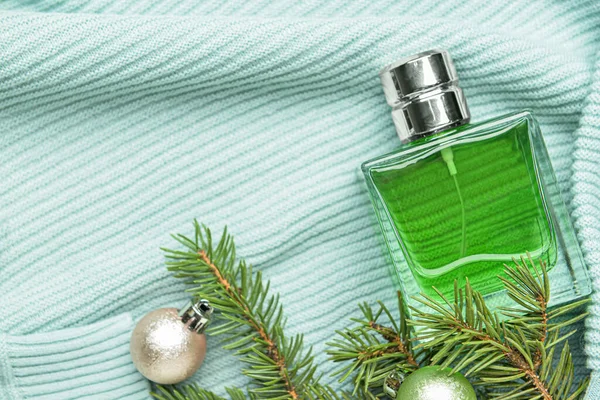 Butelka Perfum Gałąź Jodły Bożonarodzeniowymi Kulkami Dzianinie Tło — Zdjęcie stockowe