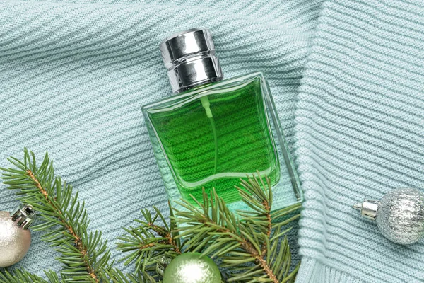 Butelka Perfum Gałąź Jodły Bożonarodzeniowymi Kulkami Dzianinie Tło — Zdjęcie stockowe