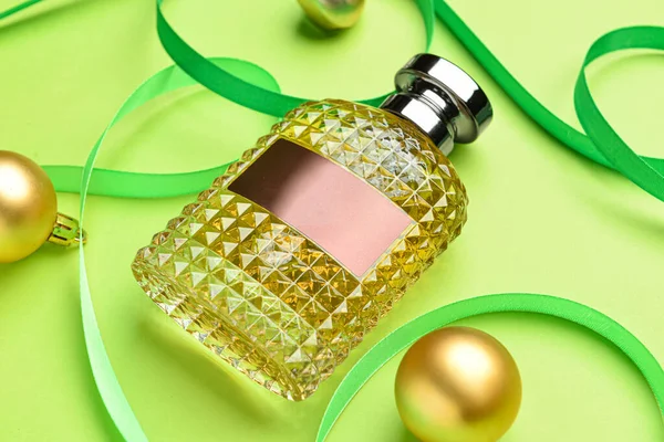 Renkli Arka Planda Bir Şişe Parfüm Kurdele Noel Topları Yakın — Stok fotoğraf