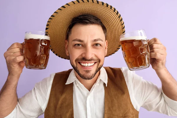 Junger Mann Traditioneller Deutscher Kleidung Mit Bier Auf Fliederfarbenem Hintergrund — Stockfoto