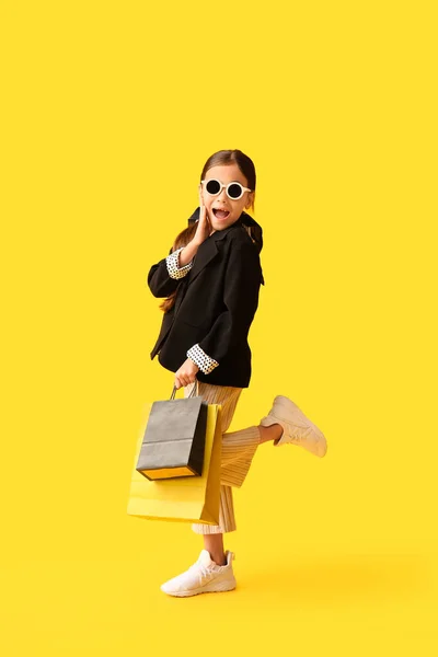 穿着黄色背景黑色星期五购物袋的令人惊讶的小女孩 — 图库照片