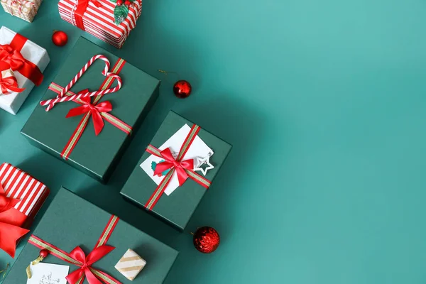 緑の背景にキャンディーの杖とボールを持つクリスマスのギフトボックス — ストック写真