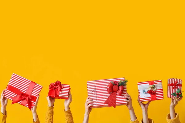 Young People Holding Christmas Gift Boxes Yellow Background — Stock Photo, Image