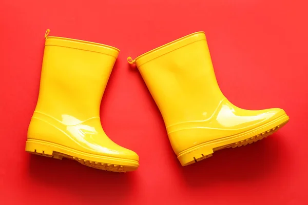 Pair of rubber boots on red background