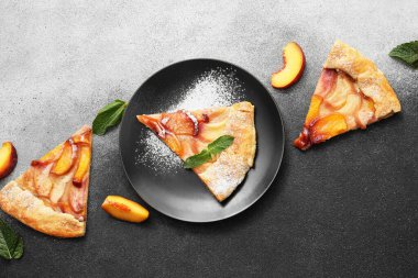 Siyah ve beyaz arka planda lezzetli şeftali galeti parçaları olan kompozisyon