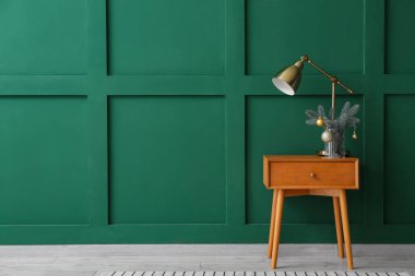 Lambalı masa ve renk duvarının yanındaki Noel dekoru.