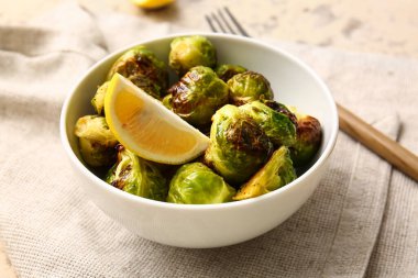 Lezzetli kızarmış Brüksel lahanası ve limonlu kase, yakın plan.