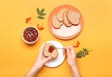 Lezzetli rowan reçelini renk arka planına sürmüş bir kadın.