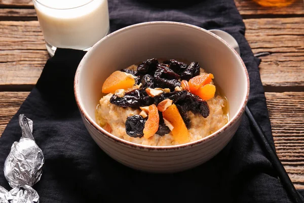 Bowl Delicious Oatmeal Prunes Dried Apricots Almond Nuts Wooden Table — Stock Photo, Image