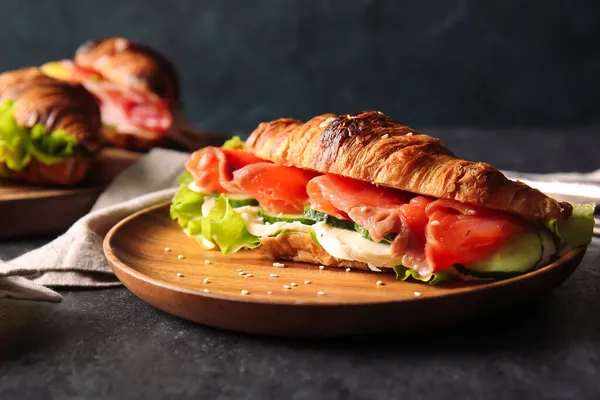 Teller Mit Leckerem Croissant Sandwich Mit Fisch Auf Schwarzem Hintergrund — Stockfoto