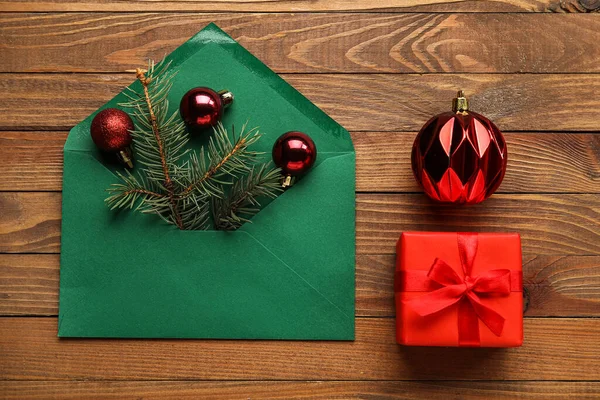 Umschlag Mit Tannenzweigen Weihnachtskugeln Und Geschenkschachtel Auf Holzgrund — Stockfoto