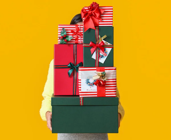 Kobieta Trzyma Pudełka Świąteczne Żółtym Tle — Zdjęcie stockowe