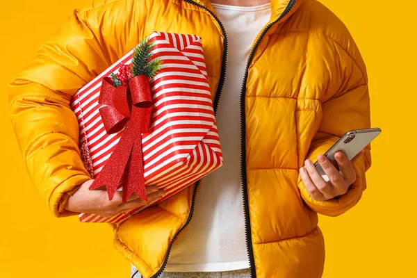 Mann Mit Weihnachtsgeschenkboxen Und Handy Auf Gelbem Hintergrund — Stockfoto