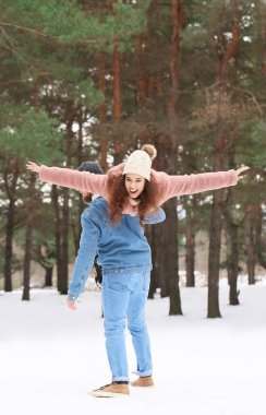 Mutlu genç çift kış günü ormanda eğleniyor.