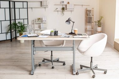 Masa ve sandalyeli modern ışık ofisinin içi