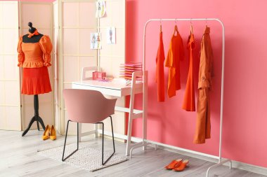 Mankenli, elbiseli ve pembe duvarın yanındaki katlanır ekranlı stilistin işyeri