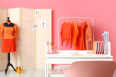 Stüdyoda manken, kıyafet ve katlama ekranlı stilistin çalışma yeri