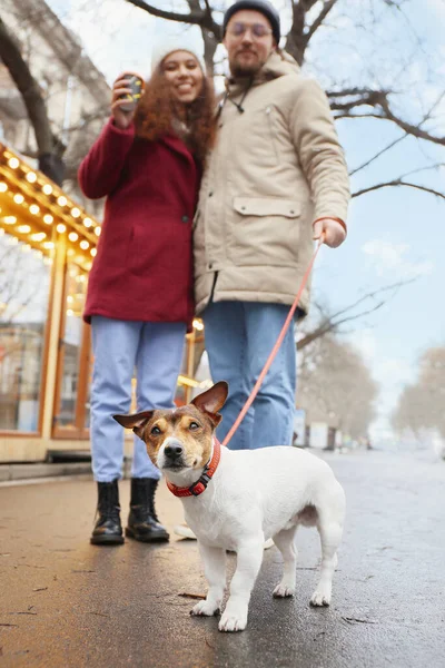 快乐的年轻夫妇带着狗在城市街道上 — 图库照片
