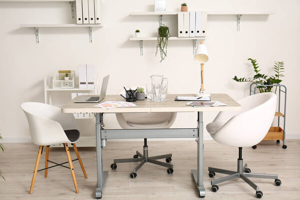 Interior of modern light office with table and chairs