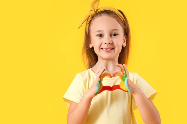 Cute Little Girl Making Heart Shape Hands Paint Yellow Background — Stock Photo, Image