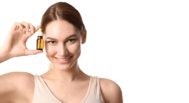 Beyaz arka planda bir şişe gerekli yağı olan mutlu kadın.