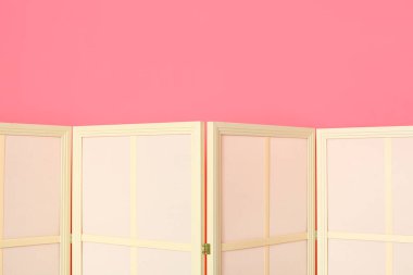 Pembe duvarın yanında ışık katlama ekranı