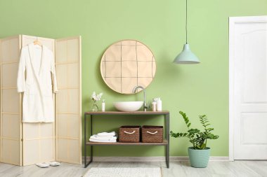 Masası ve katlanır perdesi olan şık bir banyo.