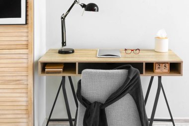 Işık duvarının yanında siyah lambalı modern işyeri