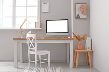 Işık ofisinde boş bilgisayar ekranı olan modern işyeri