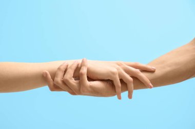 Mavi arka planda el ele tutuşan kadın ve erkek