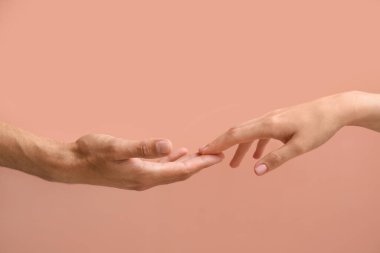 Erkek ve kadın bej arka planda parmaklarına dokunuyor