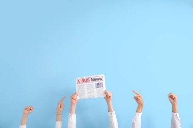 İnsanlar mavi arka plandaki gazeteyi işaret ediyor.