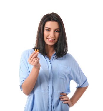 Beyaz arka planda kulak tıkacı olan genç bir kadın.