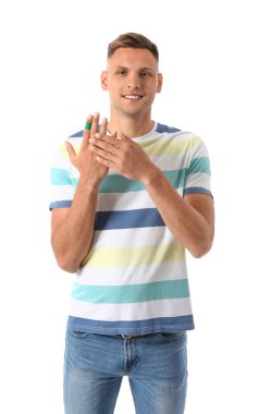 Parmağında beyaz arka planda yara bandı olan bir adam.