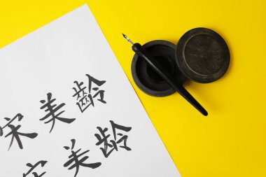 Renk arkaplanı üzerinde Asya hiyeroglifleri olan yazı ve kağıt araçları