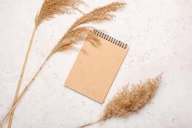 Açık arkaplanda kuru sazlıklar ve not defteri