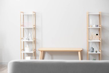 Televizyon standı ve raf üniteleriyle aydınlık oturma odasının içinde.