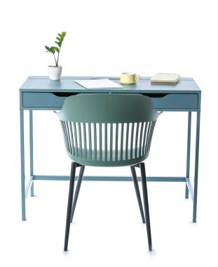 Beyaz arka planda ev bitkisi, fincan, dergi, defter ve sandalye olan modern masa