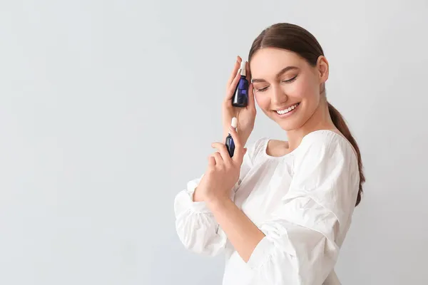 Mulher Feliz Com Olhos Fechados Segurando Garrafas Óleo Essencial Fundo — Fotografia de Stock