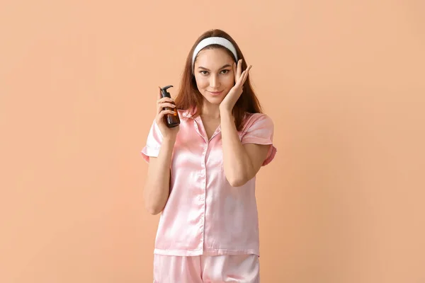 Joven Mujer Sonriente Aplicando Aceite Esencial Cara Sobre Fondo Beige —  Fotos de Stock