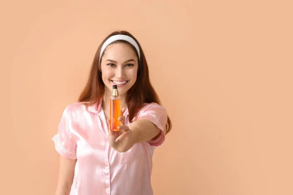 Ung Glad Kvinna Håller Sprayflaska Med Eterisk Olja Beige Bakgrund — Stockfoto