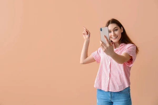 Jovem Sorrindo Mulher Tomando Selfie Apontando Para Algo Fundo Bege — Fotografia de Stock