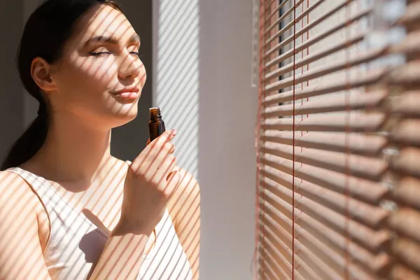 Mulher Bonita Com Olhos Fechados Cheirando Óleo Essencial Natural Perto — Fotografia de Stock