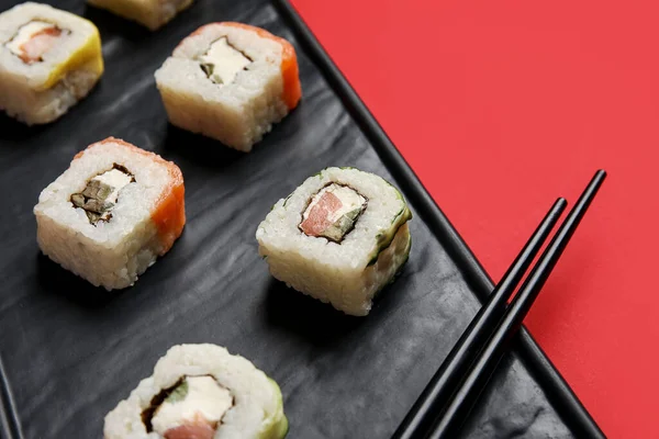 Bandeja Con Deliciosos Rollos Sushi Palillos Sobre Fondo Color Primer — Foto de Stock