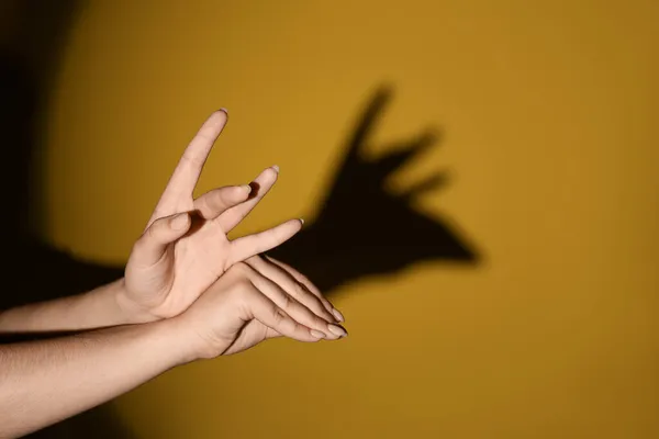 Γυναίκα Κάνει Άλκη Σκιά Χέρια Της Στο Φόντο Χρώμα — Φωτογραφία Αρχείου