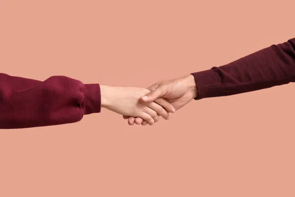 女人在米色背景上和男人握手 — 图库照片