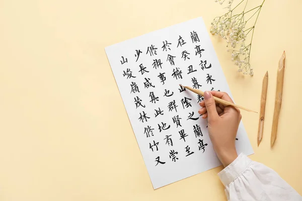 Asiatischer Kalligraph Schreibt Hieroglyphen Auf Farbigem Hintergrund — Stockfoto
