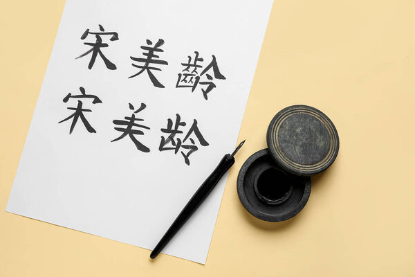 Tools for calligraphy and paper with Asian hieroglyphs on color background
