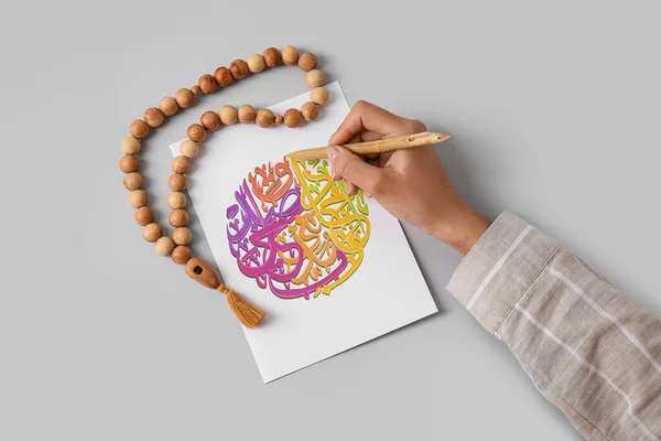 Arabische Kalligraphin Schreibt Auf Papierbogen Vor Hellem Hintergrund — Stockfoto
